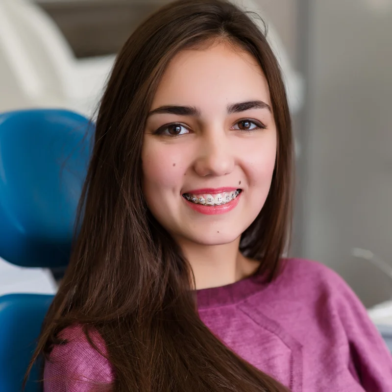 Teen patient smiling with braces during dental checkup covered by CDCP at Fairmont Dental Centre in London Ontario