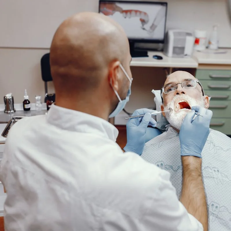 Dentist examining senior patient during denture consultation at Fairmont Dental Centre in London Ontario