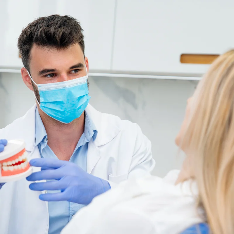 Dentist explaining treatment using tooth model during dental consultation at Fairmont Dental Centre in London Ontario