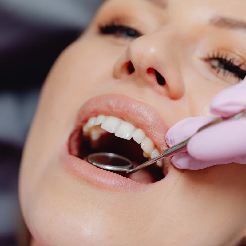 Dentist examining female patient’s teeth after oral surgery at Fairmont Dental Centre in London Ontario