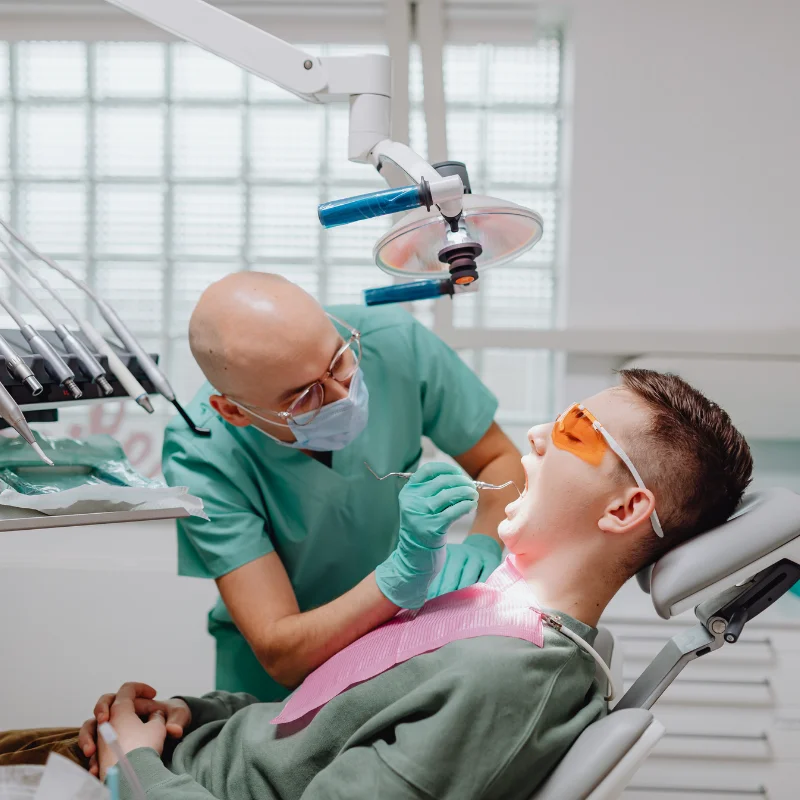Patient lying on dental chair while London dentist performs oral surgery at Fairmont Dental Centre